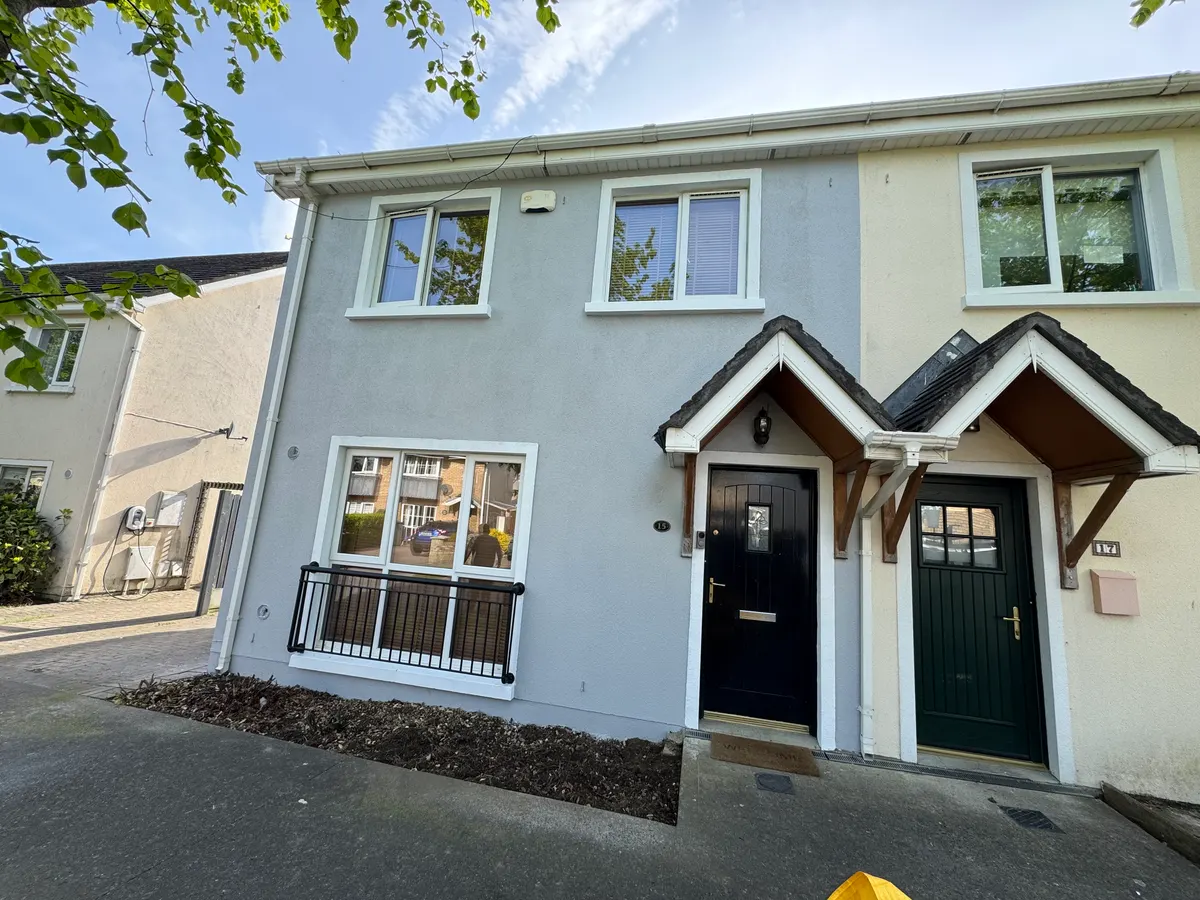 After: left-hand semi in Lusk, Co. Dublin, repainted pale grey with white window surrounds, next door still cream