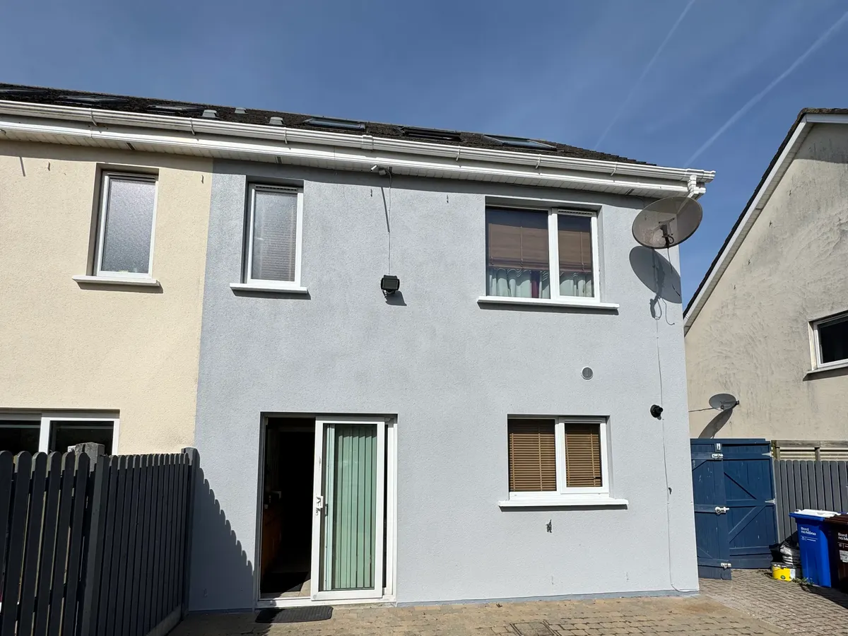 Back of a semi-detached house in Lusk, Co. Dublin, repainted pale grey beside the neighbour's cream render