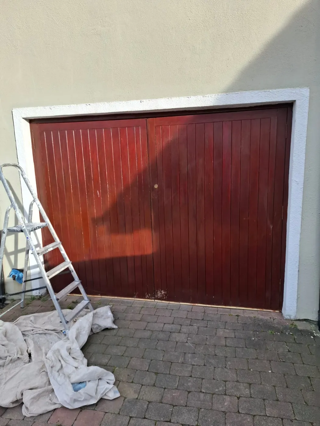 Old mahogany-stained timber garage door before repainting on a Dublin house