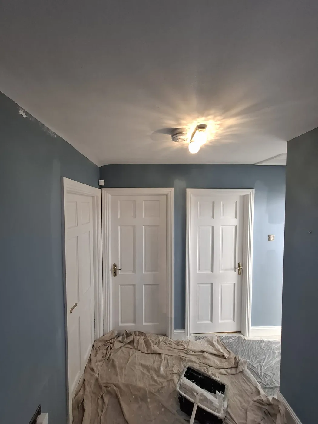 Freshly painted white panel doors and blue hallway walls in a Dublin home