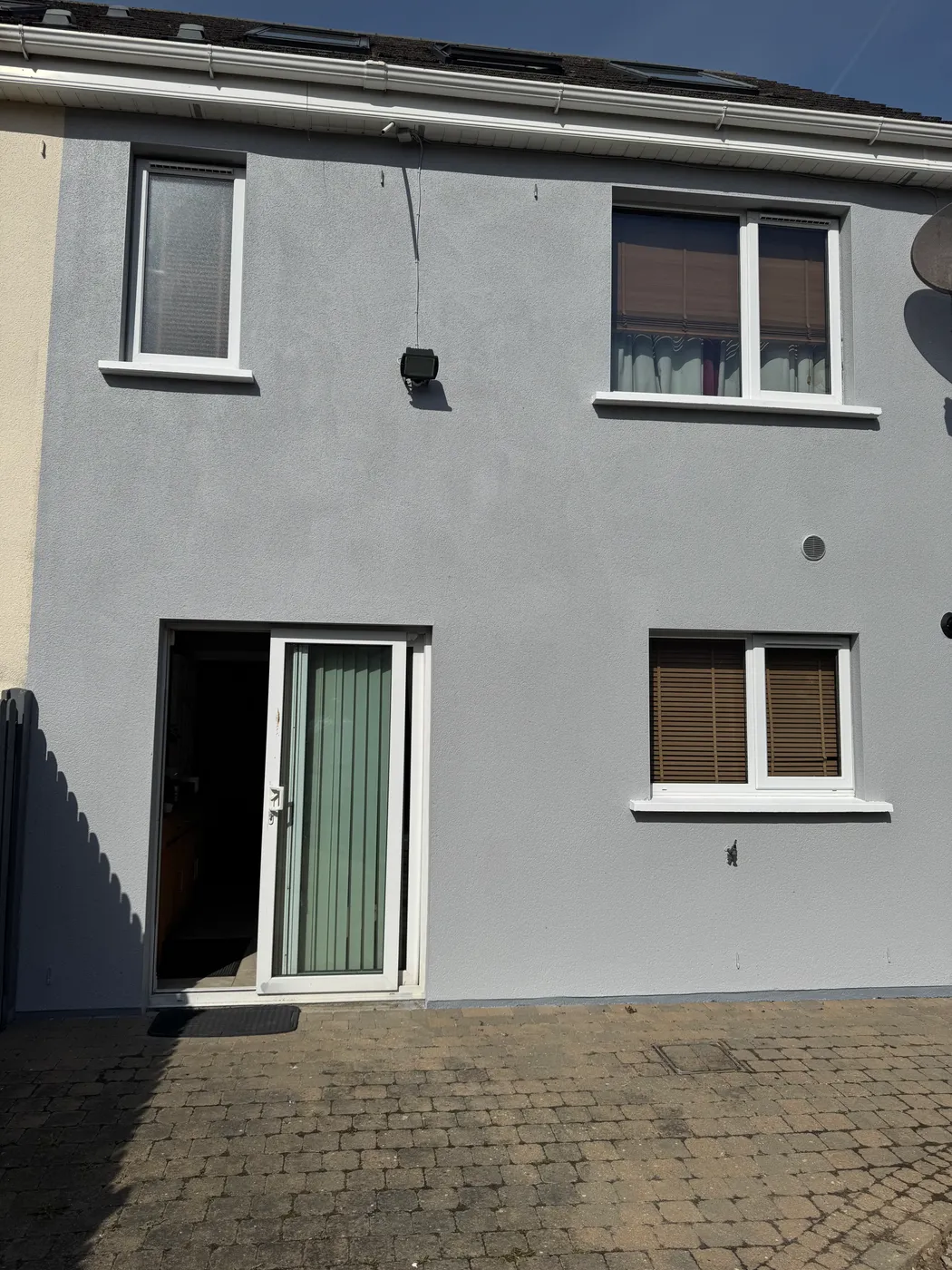 Freshly painted grey semi-detached house front with black door in Lusk, Dublin